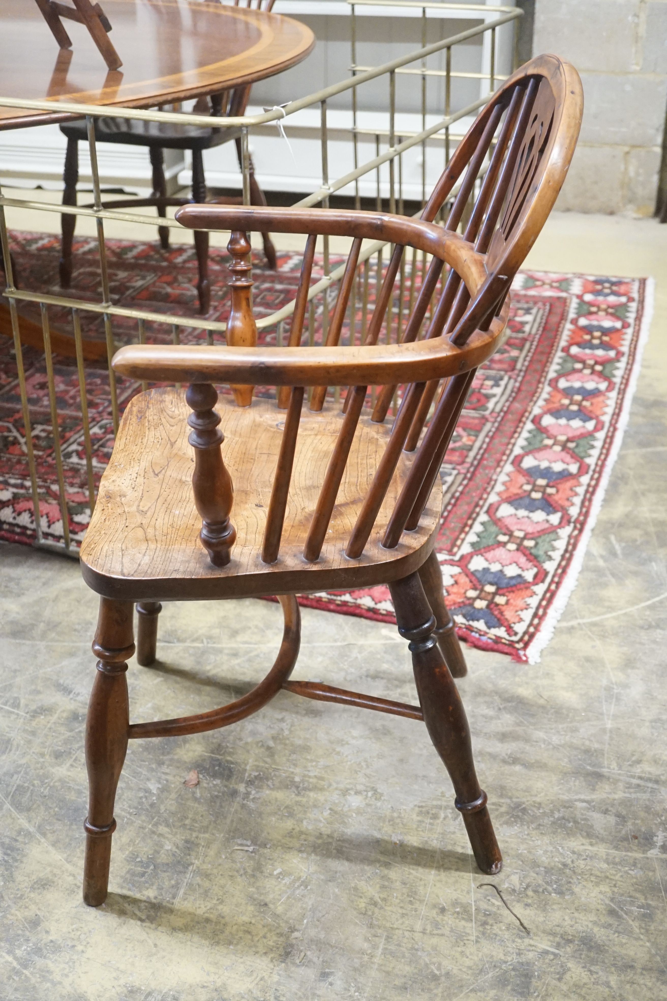 A near pair of mid 19th century Nottingham Area yew and elm Windsor elbow chairs with crinoline stretchers